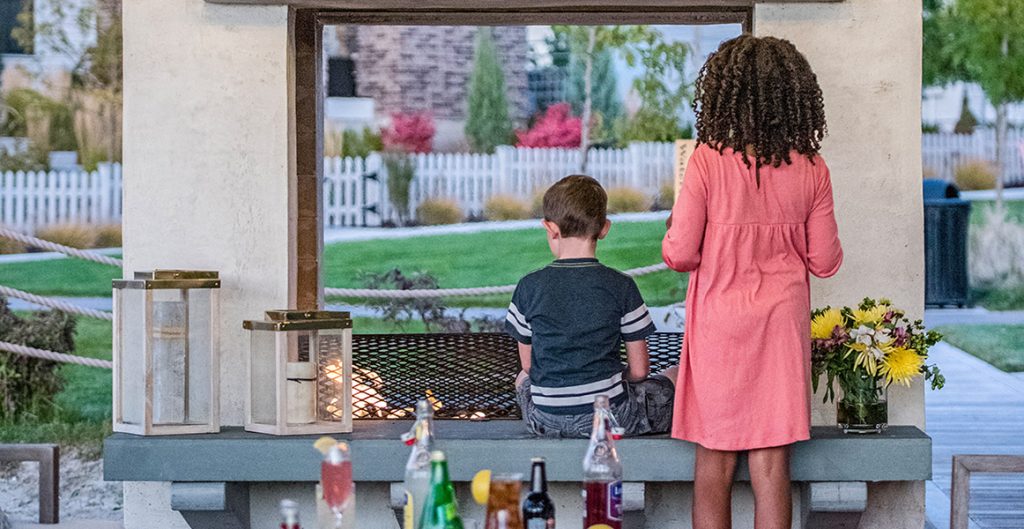 Children sitting around a fire pit in South Jordan, Utah.